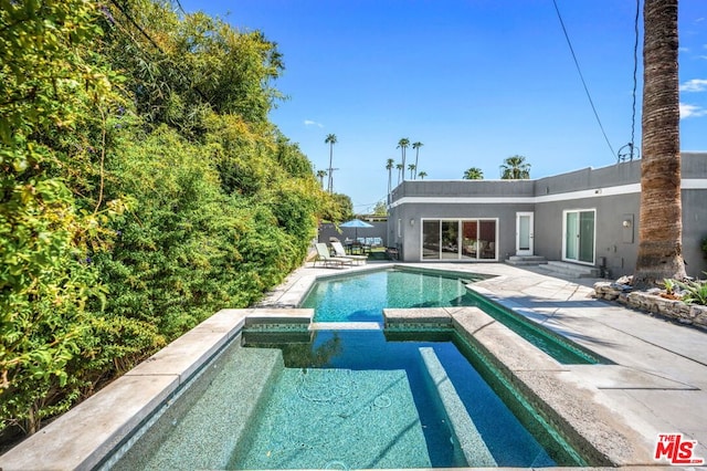 view of pool featuring a patio and an in ground hot tub