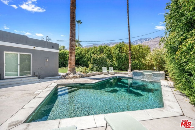 view of swimming pool with a mountain view, a patio, and an in ground hot tub