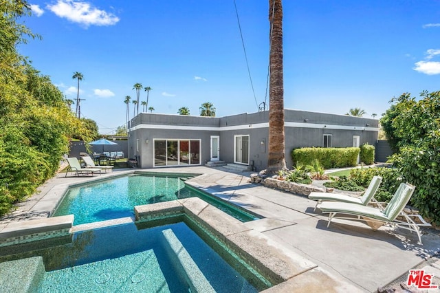 view of swimming pool featuring an in ground hot tub and a patio area