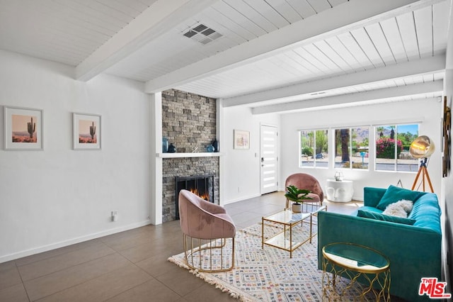 tiled living room with wood ceiling, beam ceiling, and a stone fireplace