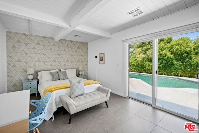 tiled bedroom with tile walls, beam ceiling, and access to exterior