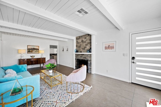 tiled living room with a fireplace and beam ceiling