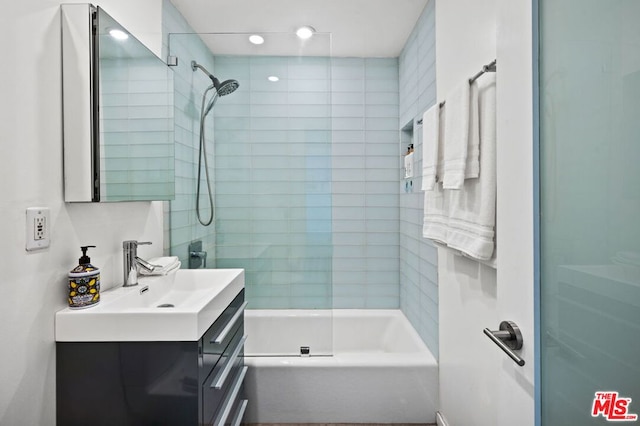 bathroom with tiled shower / bath and vanity