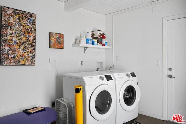 laundry area with washer and clothes dryer and dark tile patterned flooring