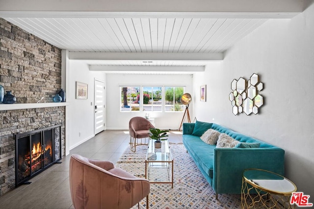 tiled living room with a fireplace and beamed ceiling