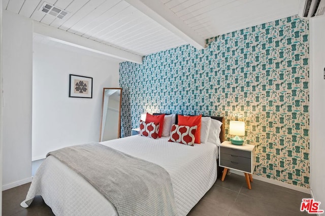 bedroom with beamed ceiling, dark tile patterned flooring, and wood ceiling