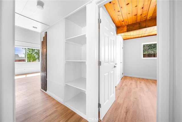 hall featuring light hardwood / wood-style floors, wood ceiling, and lofted ceiling with beams