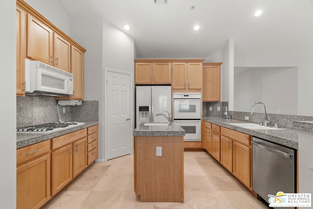 kitchen with a center island with sink, sink, stainless steel appliances, and tasteful backsplash