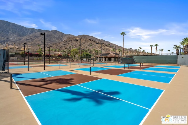 view of tennis court with a mountain view and basketball hoop