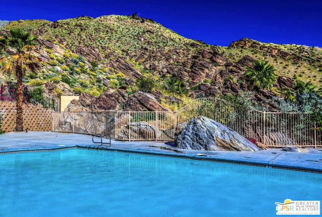 view of swimming pool with a mountain view