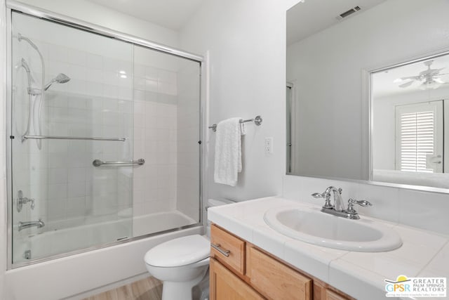 full bathroom with enclosed tub / shower combo, ceiling fan, vanity, wood-type flooring, and toilet