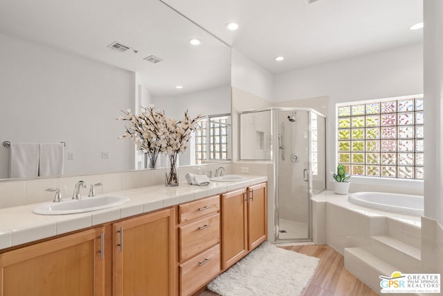 bathroom with vanity, shower with separate bathtub, and hardwood / wood-style floors