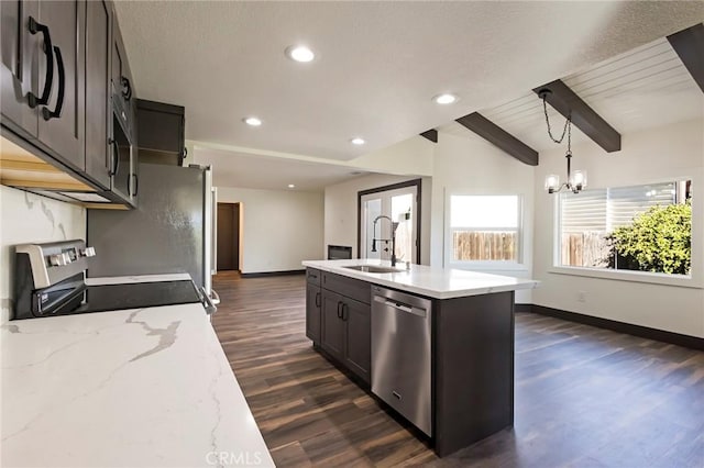 kitchen featuring beamed ceiling, sink, hanging light fixtures, a kitchen island with sink, and stainless steel appliances