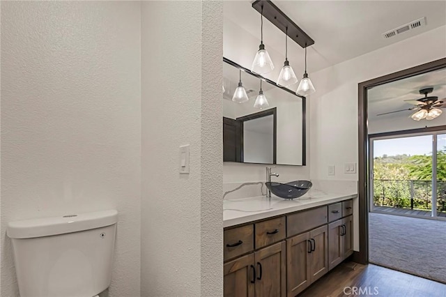 bathroom featuring vanity, hardwood / wood-style floors, ceiling fan, and toilet