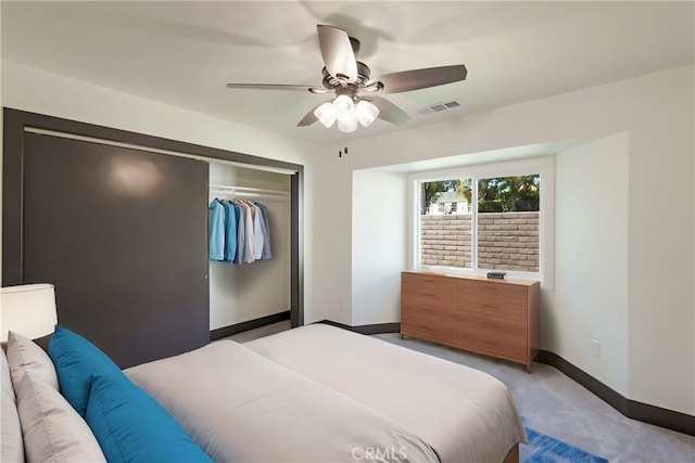 carpeted bedroom featuring ceiling fan and a closet