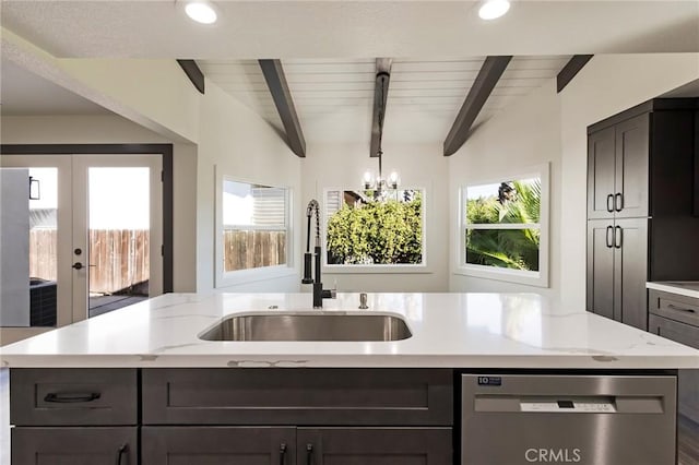 kitchen featuring beamed ceiling, stainless steel dishwasher, sink, and a center island with sink