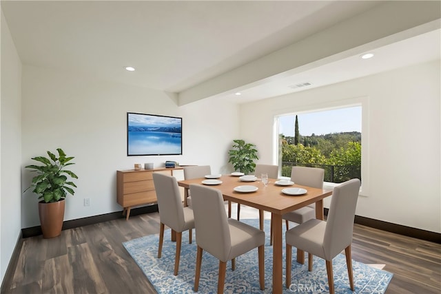 dining space with dark hardwood / wood-style floors and beamed ceiling