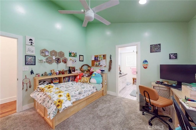 carpeted bedroom with ensuite bath and vaulted ceiling