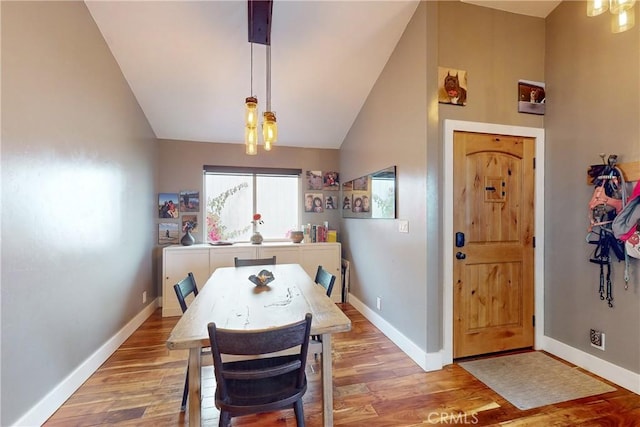 dining space featuring lofted ceiling and light hardwood / wood-style floors