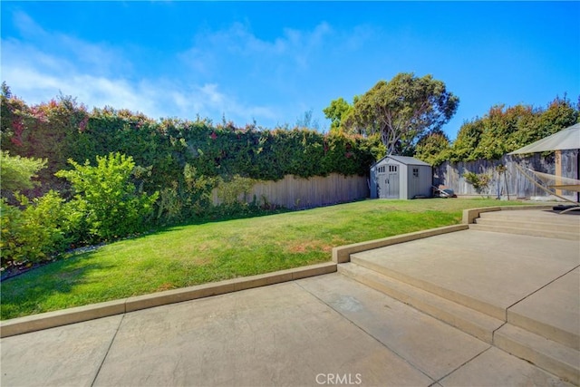 view of yard featuring a storage shed and a patio area