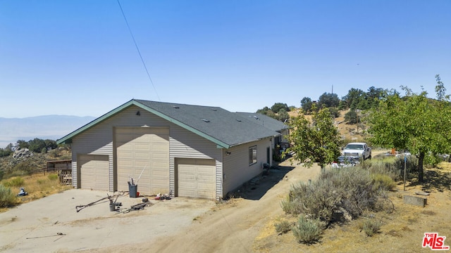 exterior space featuring an outdoor structure, a garage, and a mountain view