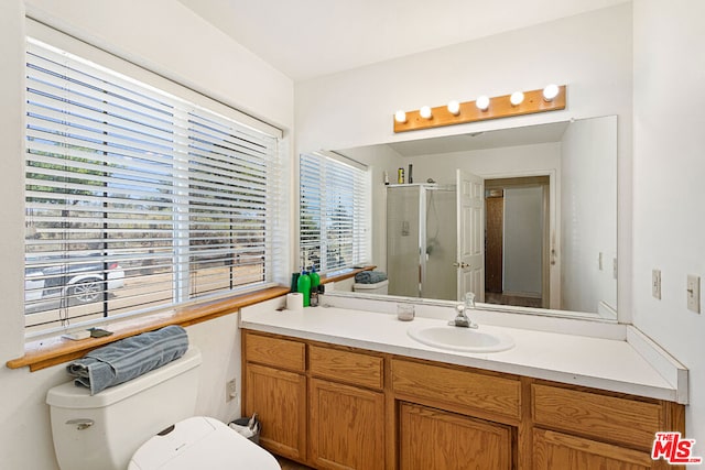 bathroom featuring walk in shower, vanity, and toilet