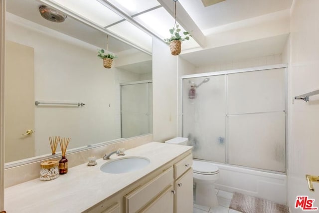 full bathroom featuring enclosed tub / shower combo, vanity, toilet, and tile patterned floors