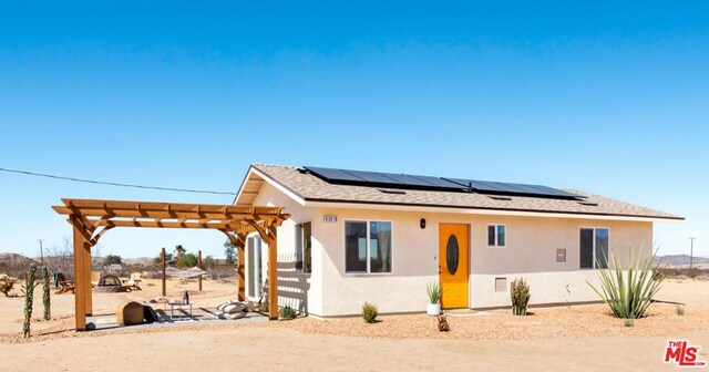 view of front facade with a pergola and solar panels