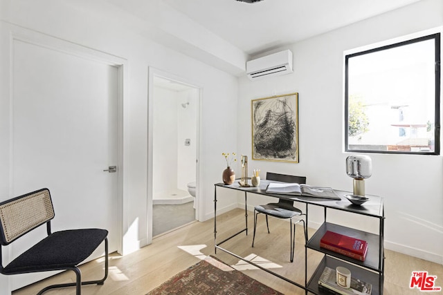 office featuring light wood-type flooring and a wall mounted air conditioner