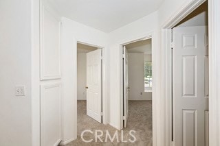 hall featuring light colored carpet