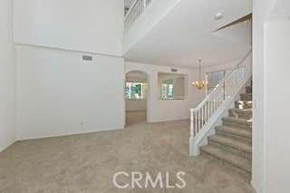 interior space featuring carpet and a chandelier