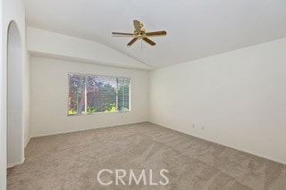 carpeted spare room featuring lofted ceiling and ceiling fan