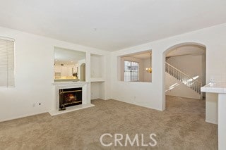 unfurnished living room with light colored carpet