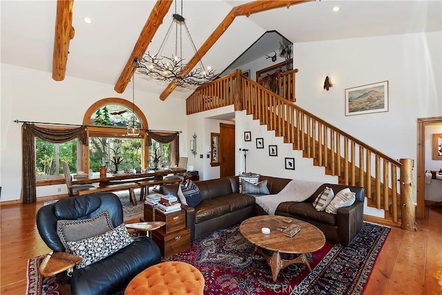 living room featuring an inviting chandelier, beam ceiling, hardwood / wood-style floors, and high vaulted ceiling