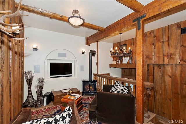 living room featuring a wood stove, a chandelier, and beamed ceiling