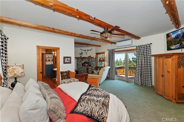 bedroom featuring carpet, an AC wall unit, access to outside, beamed ceiling, and a stone fireplace