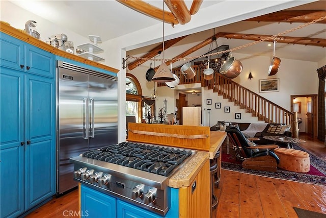 kitchen with blue cabinetry, dark hardwood / wood-style flooring, stainless steel appliances, and vaulted ceiling with beams