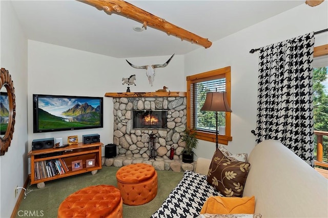 living room with carpet floors, a fireplace, and beamed ceiling