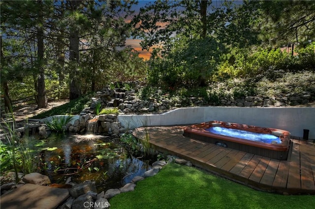 pool at dusk featuring a deck