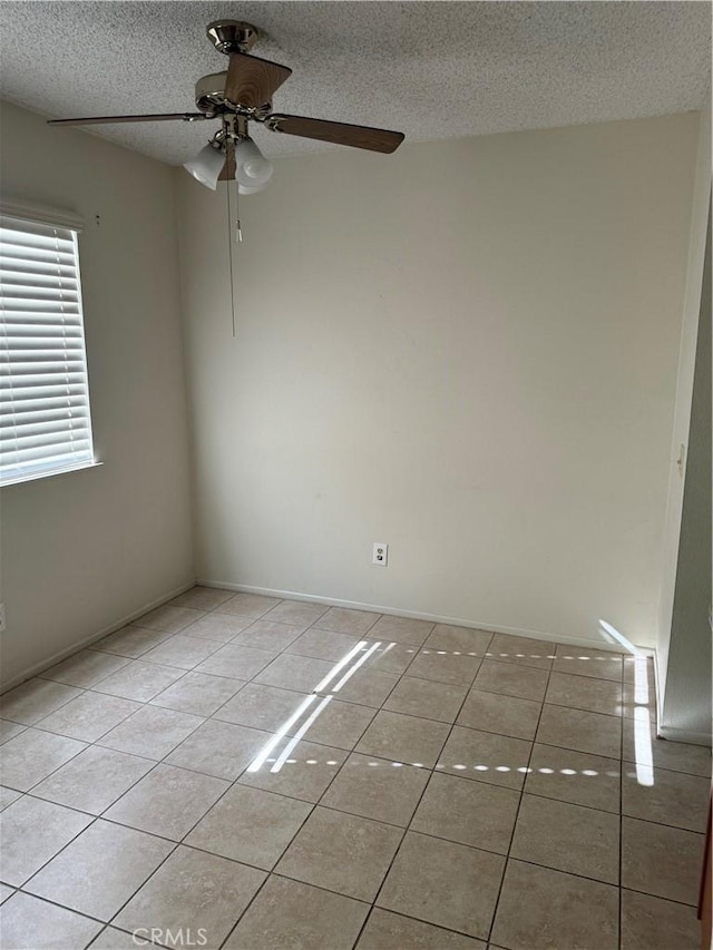 spare room featuring light tile patterned floors, a textured ceiling, and ceiling fan