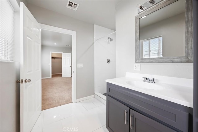 bathroom featuring a shower, vanity, and tile patterned flooring