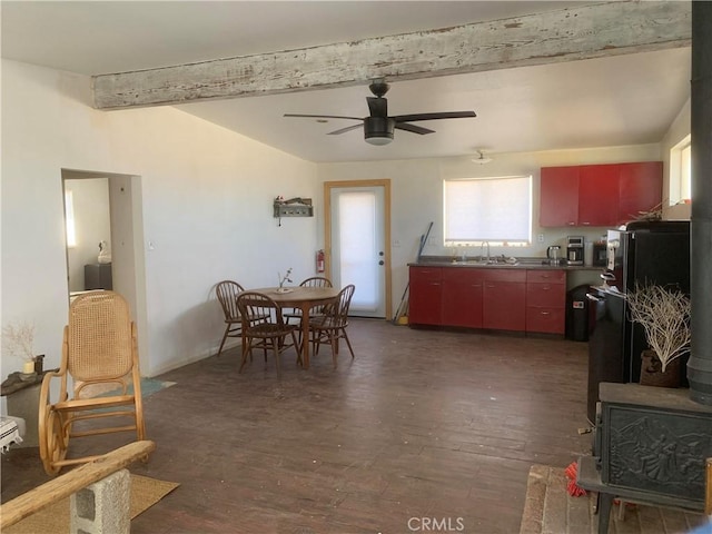 dining room featuring ceiling fan, beam ceiling, and dark hardwood / wood-style flooring