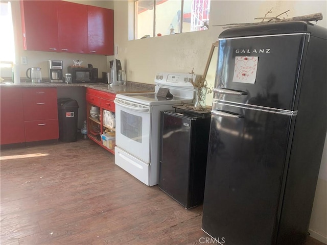 kitchen with light hardwood / wood-style flooring and black appliances