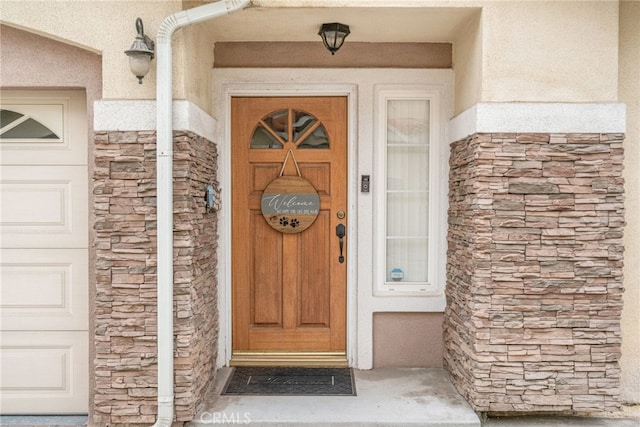 property entrance featuring stone siding and stucco siding