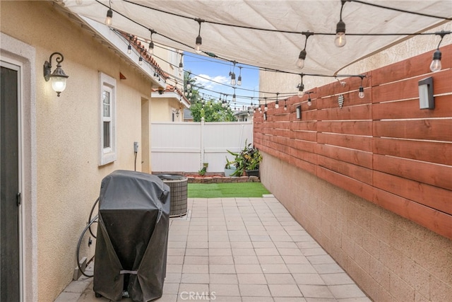 view of patio featuring central air condition unit, a grill, and fence