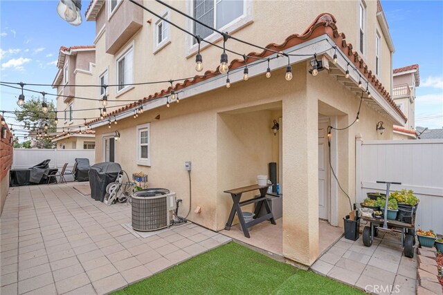 view of patio featuring central AC unit, grilling area, and fence