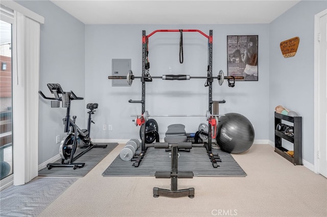 workout room featuring baseboards and carpet flooring