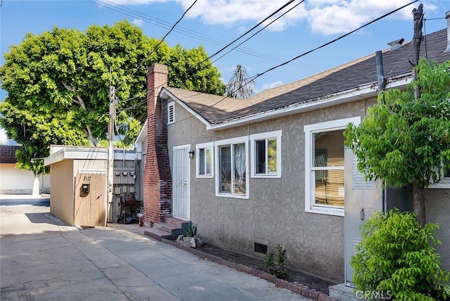 view of home's exterior with a patio and a shed