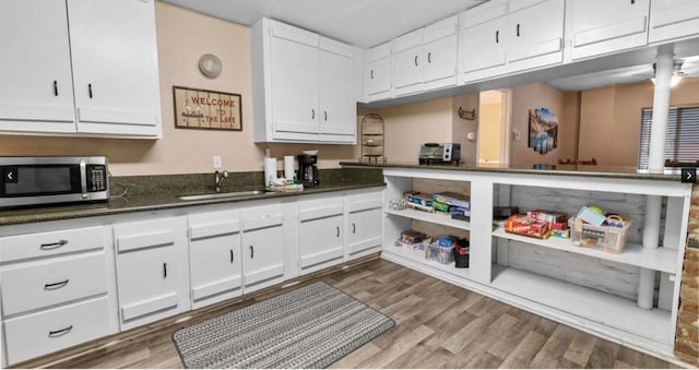 kitchen featuring sink, dark wood-type flooring, and white cabinetry