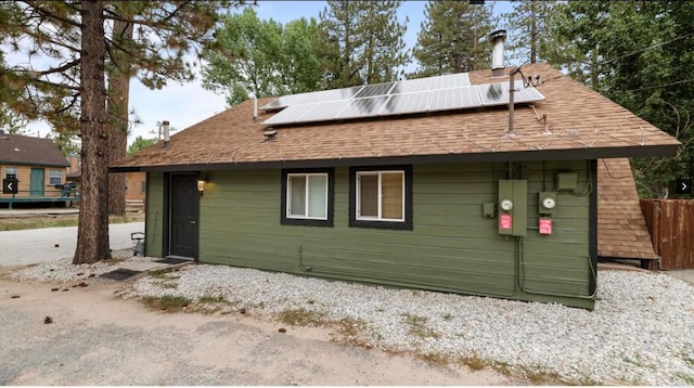 rear view of house featuring solar panels